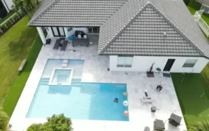 Compact pool with an integrated square spa, paver deck and covered outdoor living area built by SFC Pool Corp in Port Charlotte, Florida